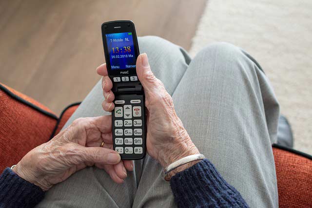 стара жена държи телефон