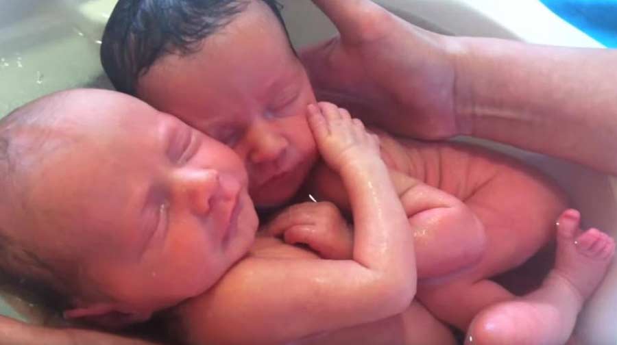 Тези новородени близнаци се наслаждават на първата си баня заедно